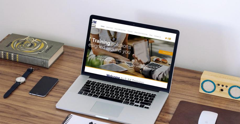SJM Training website displayed on a macbook