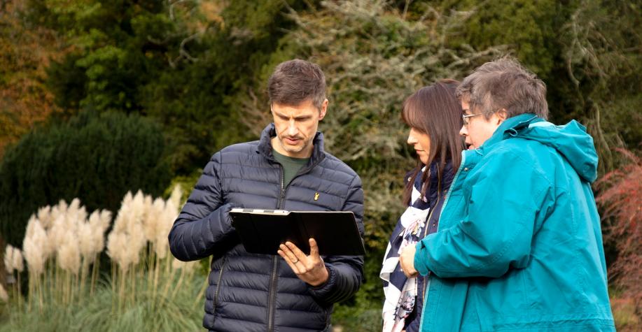 A man showing two women how to use an ipad