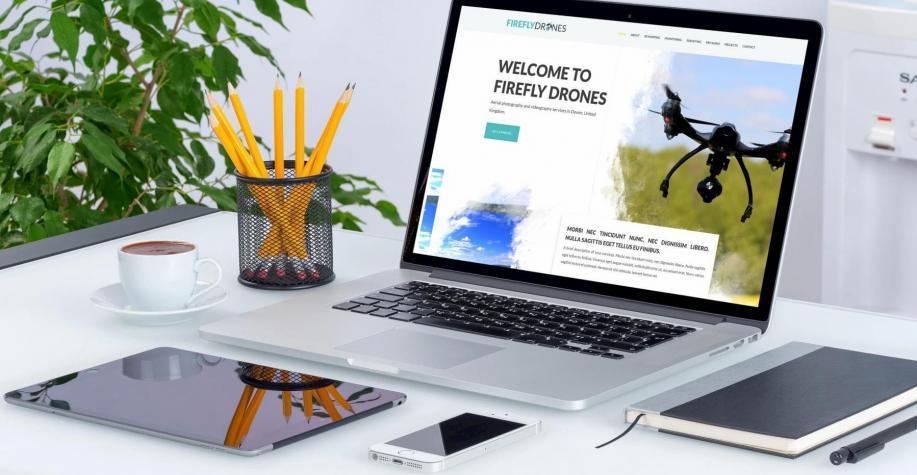 Firefly Drones website design displayed on a Macbook on a white desk