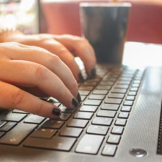 Hands typing on a laptop